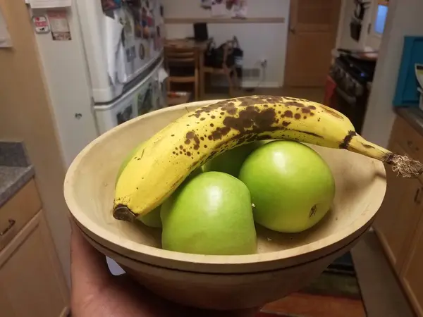 台所でりんごとバナナを手に持って — ストック写真
