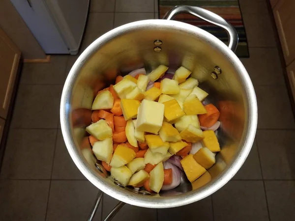 Manteiga e cenouras e abóbora e cebola em panela de metal na cozinha — Fotografia de Stock