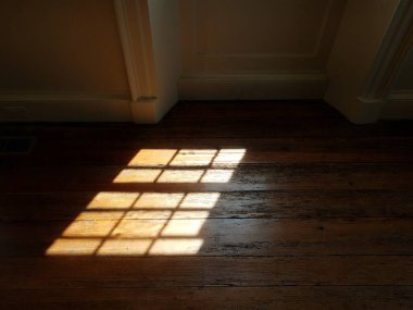 Ahşap zemindeki cam pencereden gelen ışık