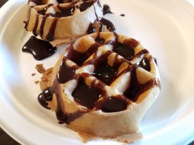 Çikolata şurubu, beyaz tabakta waffle üzerinde.