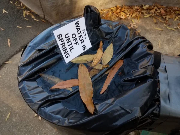 Eau jusqu'à ce que le signe de source et sac en plastique sur la fontaine d'eau — Photo