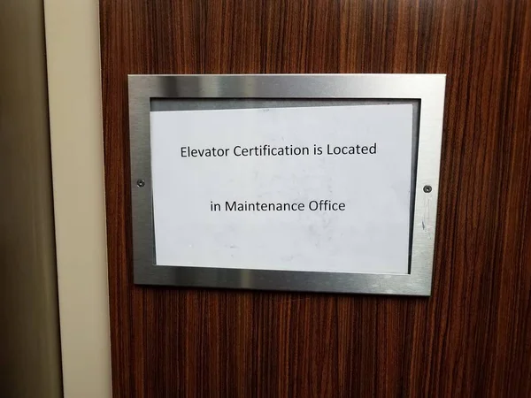 纸制升降机证书位于维修办公室标志内 — 图库照片