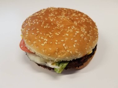 Peynirli, marullu ve domatesli hamburgerler beyaz arka planda veya masada