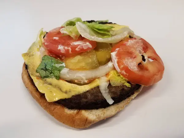 Hambúrguer com queijo e alface e tomate sobre fundo branco ou superfície — Fotografia de Stock