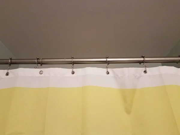 Cortina de chuveiro amarelo e branco com barra de metal — Fotografia de Stock