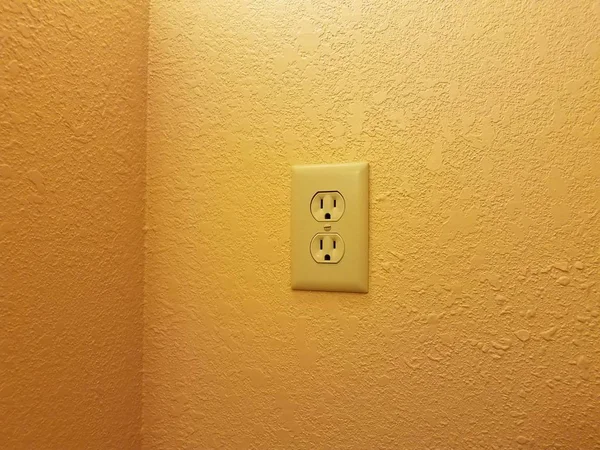 Tomada elétrica na parede pintada laranja ou amarela — Fotografia de Stock