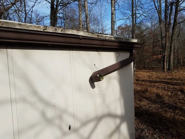 Broken gutter downspout on shed in forest or woods — Stock Photo, Image