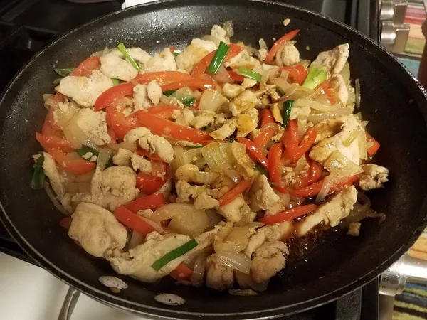 Pimentas de frango e vermelho e cebola na frigideira — Fotografia de Stock