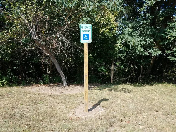 Reserviertes Parkschild im Gras oder Rasen mit Bäumen — Stockfoto