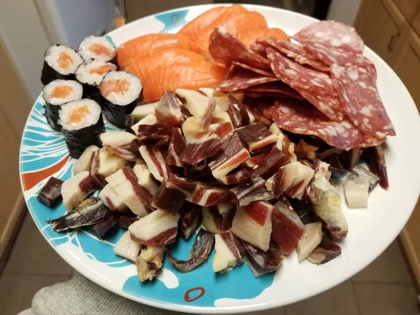 Plate with ham and salami and salmon sushi — Stock Photo, Image