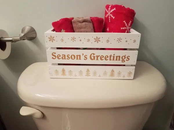Drewniane pudełko z sezonami pozdrowienia i ręczniki na toalecie — Zdjęcie stockowe