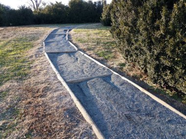 Taşlı tepe ya da çakıl yolu ya da patika ve çimen