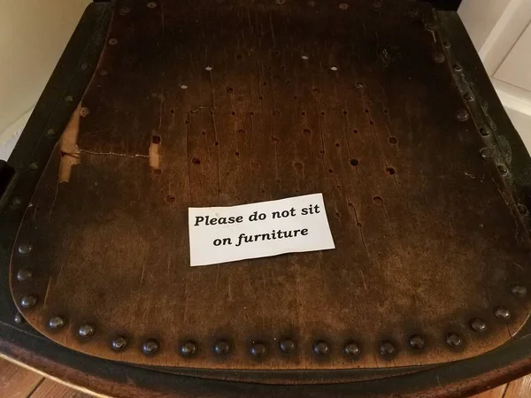 Por favor, no se siente en el letrero de muebles en silla de madera marrón viejo — Foto de Stock