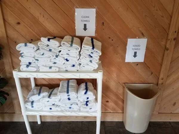 Portasciugamani bianco con cartelli e secchio per asciugamani sporchi — Foto Stock