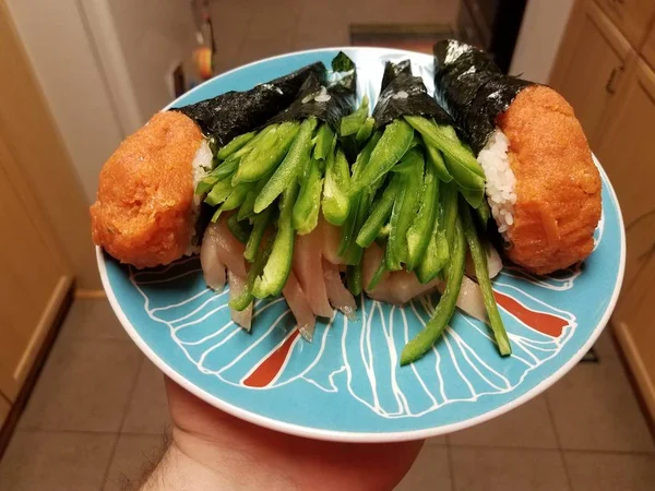 Ruční držení sushi rolky s pikantní zelenou paprikou a tuňákem — Stock fotografie