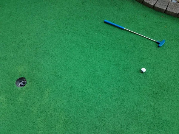 Мини-гольф с клюшкой, мячом и зеленой травой — стоковое фото