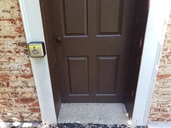 Brązowe drzwi z symbolem i przyciskiem wózka inwalidzkiego — Zdjęcie stockowe