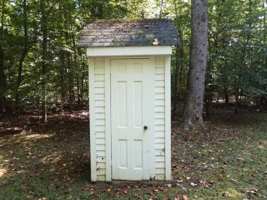 Beyaz bir ek bina ya da kapı ve ağaçlarla kaplı bir kulübe.