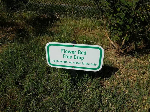 Flower bed free drop sign on grass on golf course — 스톡 사진