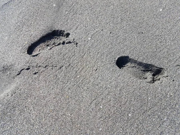 Pegada na pista em areia cinzenta molhada na praia — Fotografia de Stock