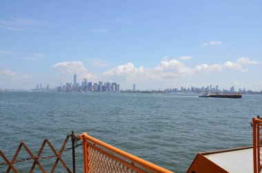 turuncu metal çit, nehir suyu ve New York binaları