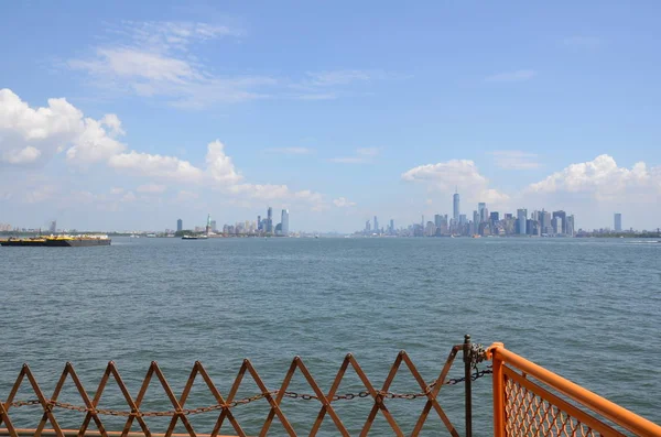 Orangefarbener Metallzaun, Flusswasser und neue Gebäude in New York — Stockfoto
