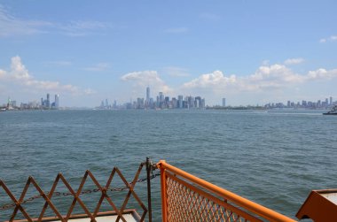 turuncu metal çit, nehir suyu ve New York binaları