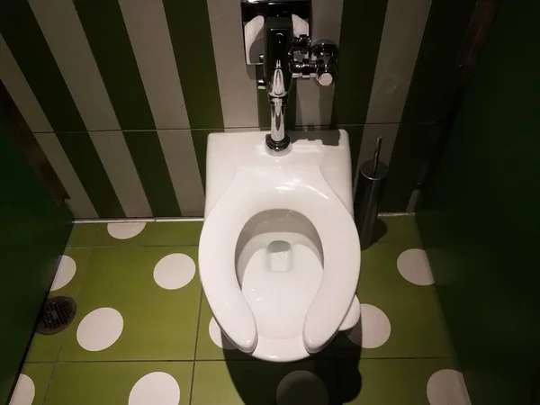 Toilet in restroom with green and white wall and tiles — Stok Foto