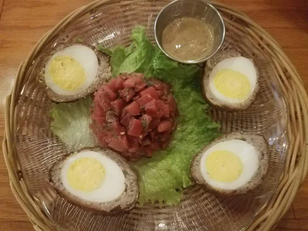 Scotch eggs with sausage and beets and lettuce