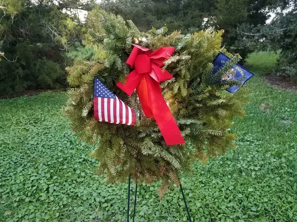 green wreath with red bow and flag of the United States veterans