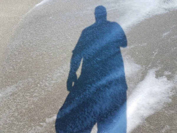 Árnyéka ember nedves homok vízzel — Stock Fotó