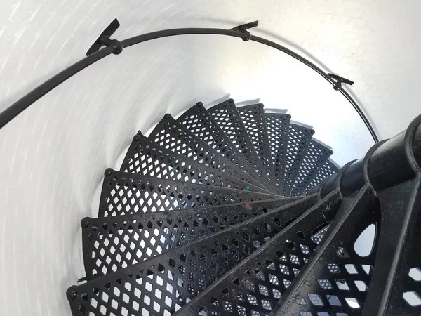 Black iron metal spiral staircase and white wall in lighthouse — Foto Stock