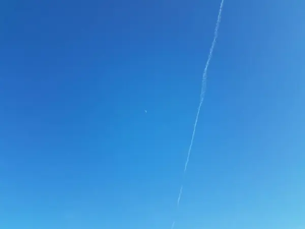 Moon and contrail or cloud in blue sky — 스톡 사진