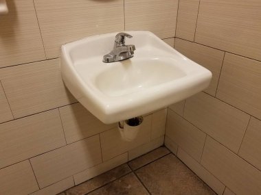 white sink in bathroom or restroom with wall tiles