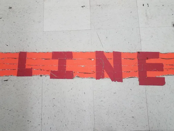 Orange and red line sign on floor with white tiles — Φωτογραφία Αρχείου
