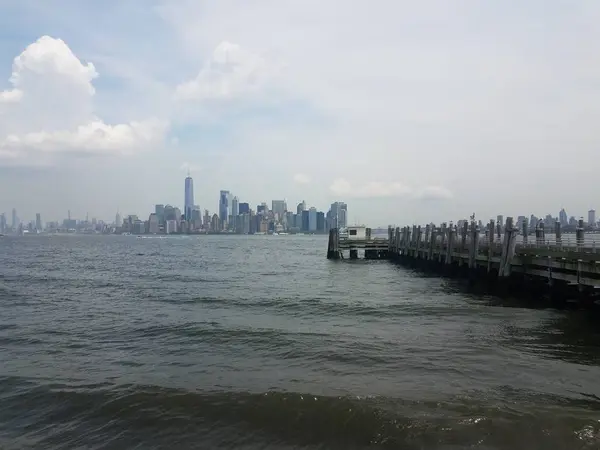 Wood pier or dock with river water and New York city — Stockfoto