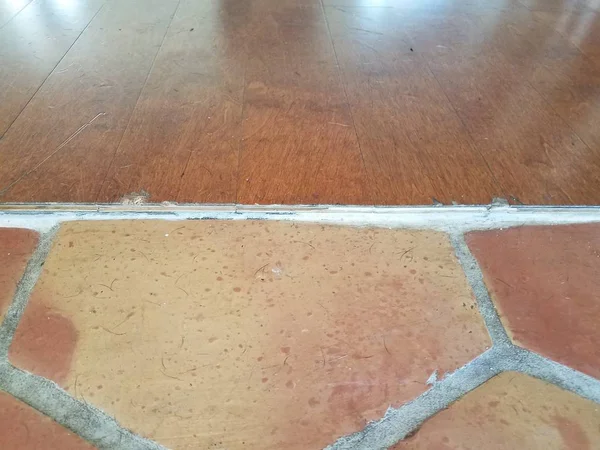 Threshold between wood floor and tile floor with hairs — Foto Stock