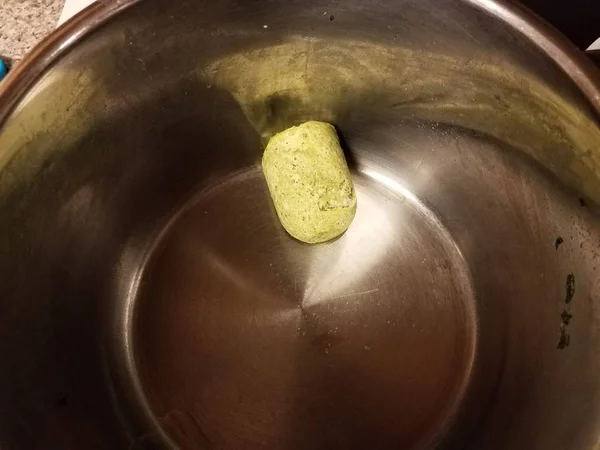 Frozen green pesto sauce in a metal pan on stove — Stockfoto