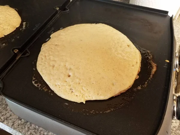 Pancake cooking on a griddle or stove — Stock Photo, Image