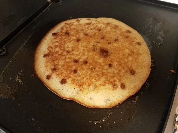 Pancake cooking on a griddle or stove — 스톡 사진