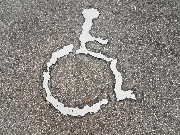 White wheelchair or handicapped symbol on asphalt — Fotografia de Stock