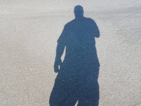 Schaduw van de mens op nat zand op het strand — Stockfoto