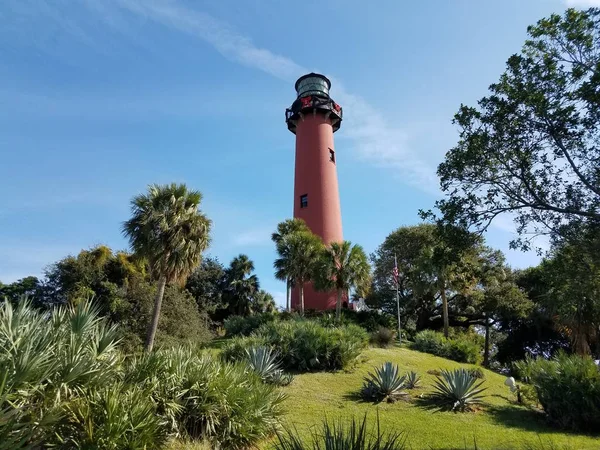 Tall red lighthouse in Florida with trees and holiday decorations — Stock Photo, Image