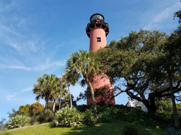 Wysoka czerwona latarnia morska na Florydzie z drzewami i dekoracjami wakacyjnymi — Zdjęcie stockowe