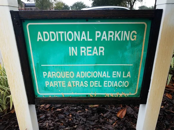 Green additional parking in rear sign in English and Spanish — Stock Photo, Image