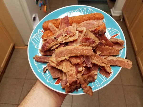 Main tenant pile de viande de bacon et rouleau de poulet sur plaque bleue — Photo
