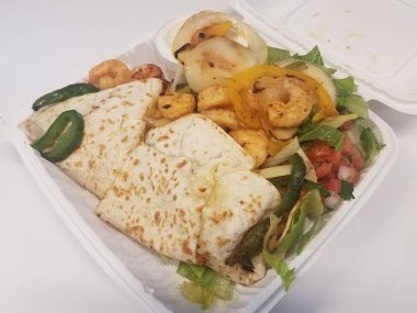 Karides, soğan ve domatesli tortilla ve kabın içinde marul.