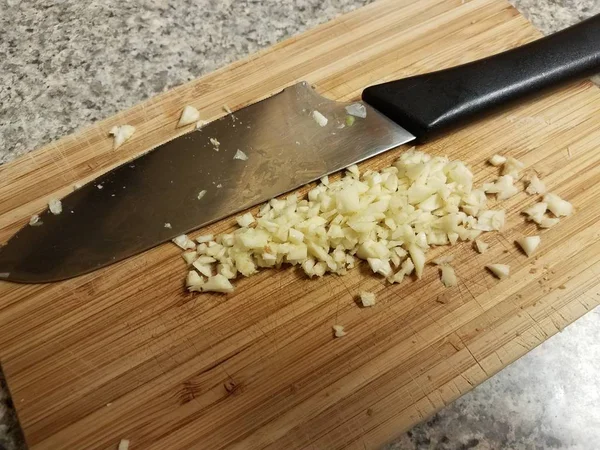Minced garlic on a cutting board with knife — 스톡 사진