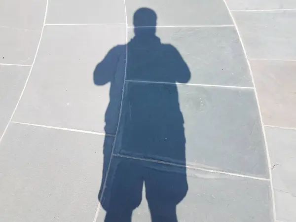 Sombra del hombre con baldosas de piedra gris o piso — Foto de Stock