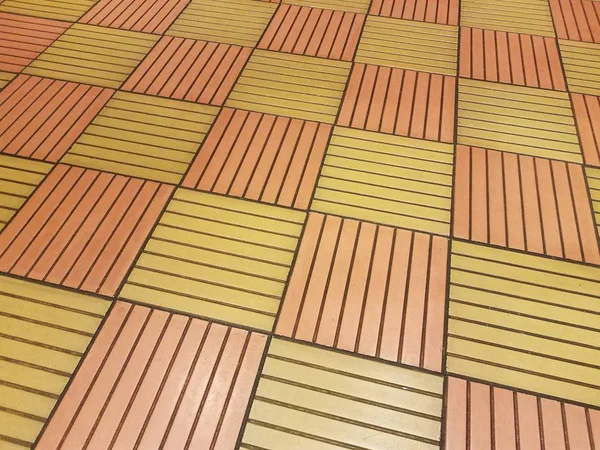 Telhas quadradas laranja e amarela no chão — Fotografia de Stock
